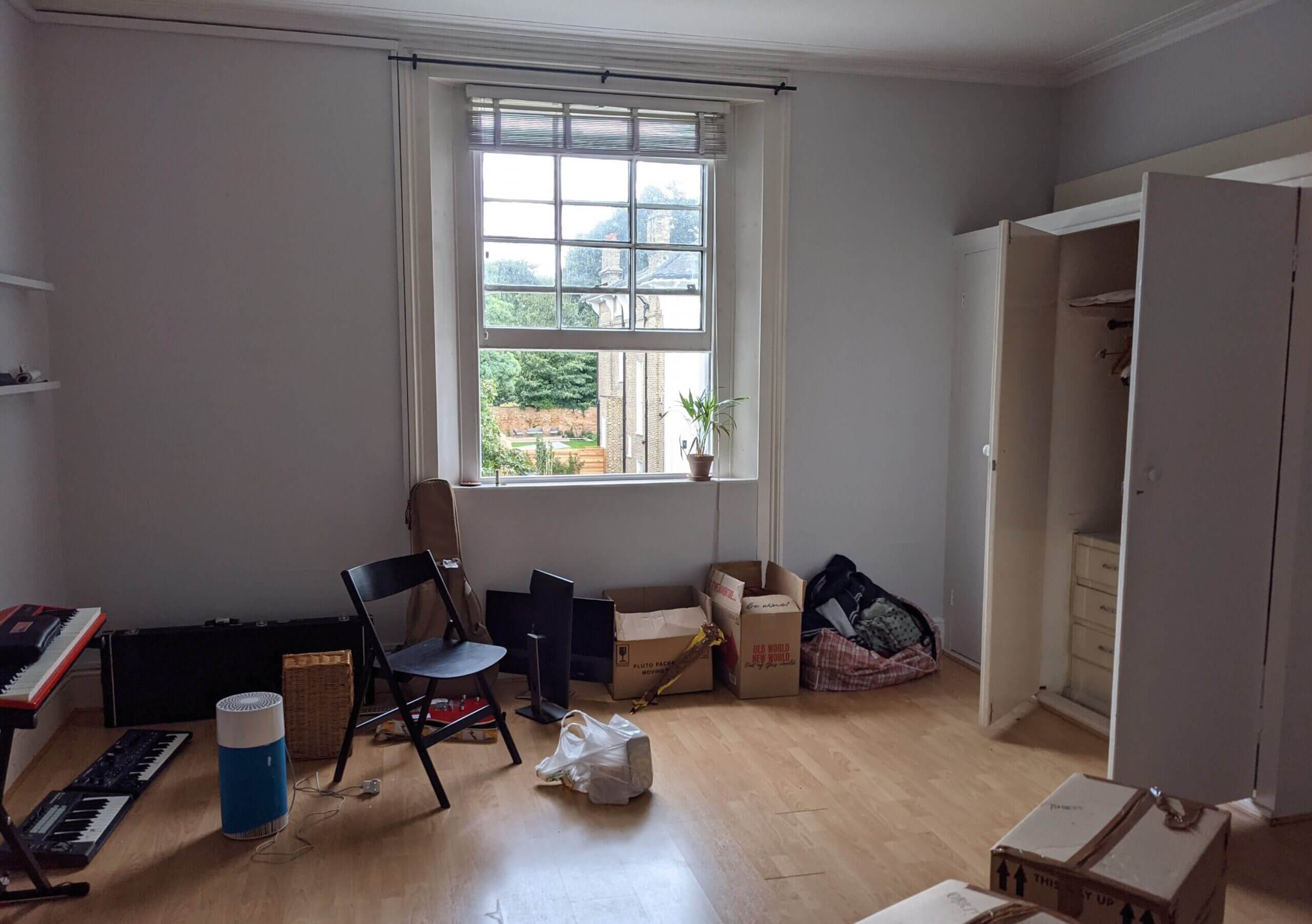 a room filled with cardboard boxes and the natural light coming through the single large window